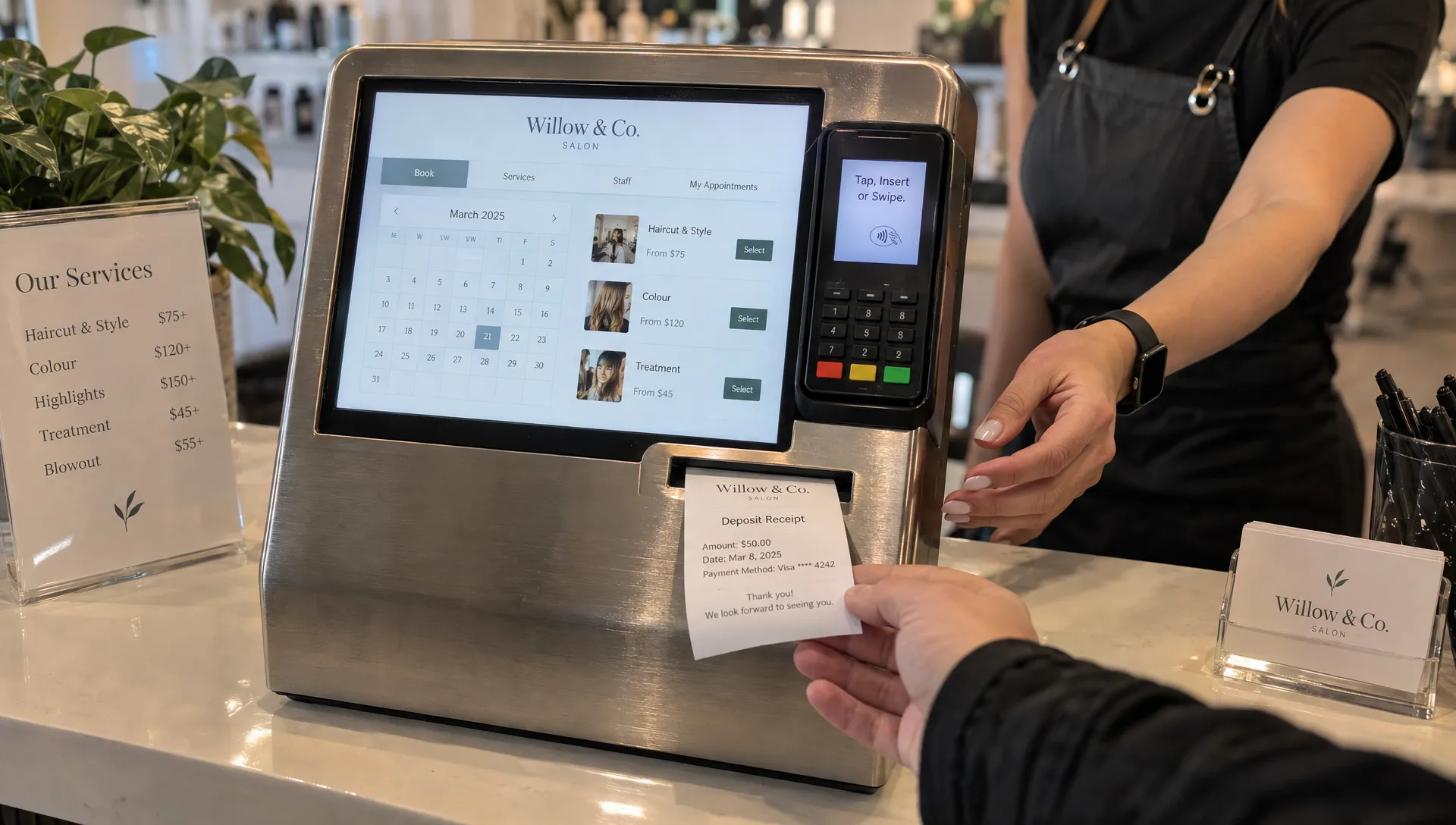 A salon deposit receipt emerges from a booking terminal as a stylist reaches across the counter, showing a payment recorded before the service.